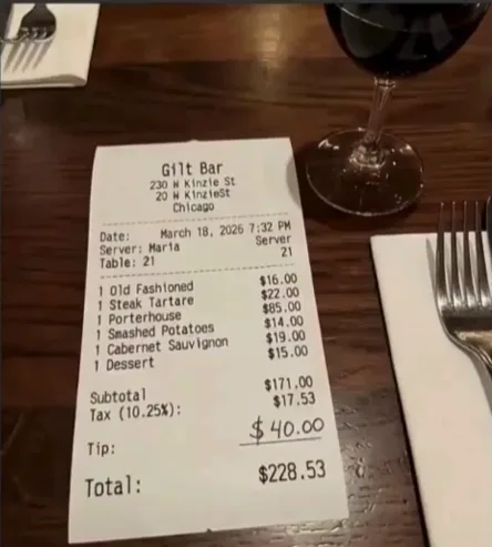 Off-angle phone photo of a real restaurant receipt at a dimly-lit table